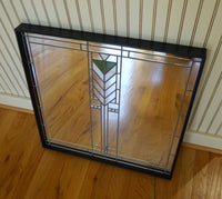 Art Deco square mirror in black frame sits on floor